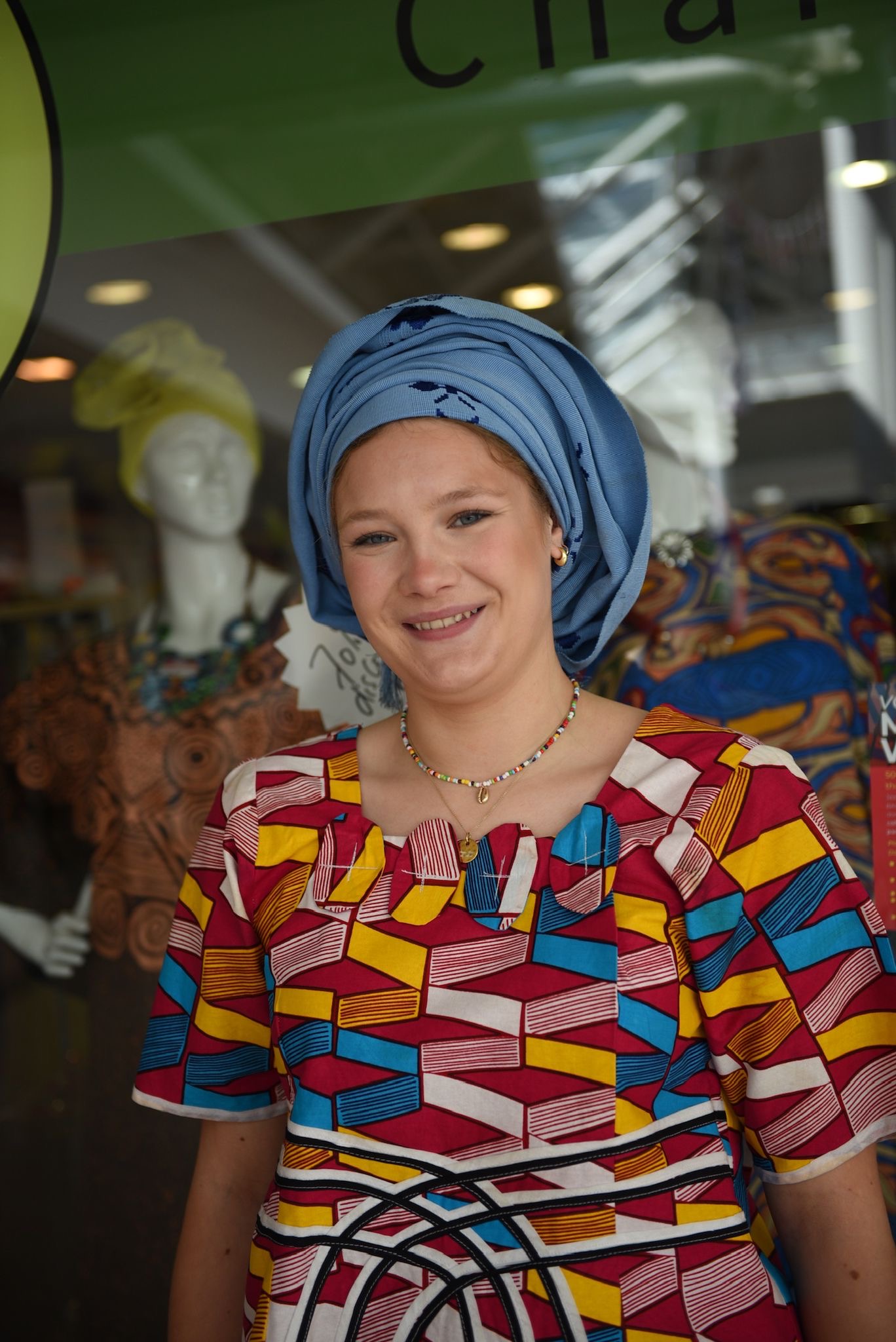 Portrait of a guest in a blue headwrap and colorful dress