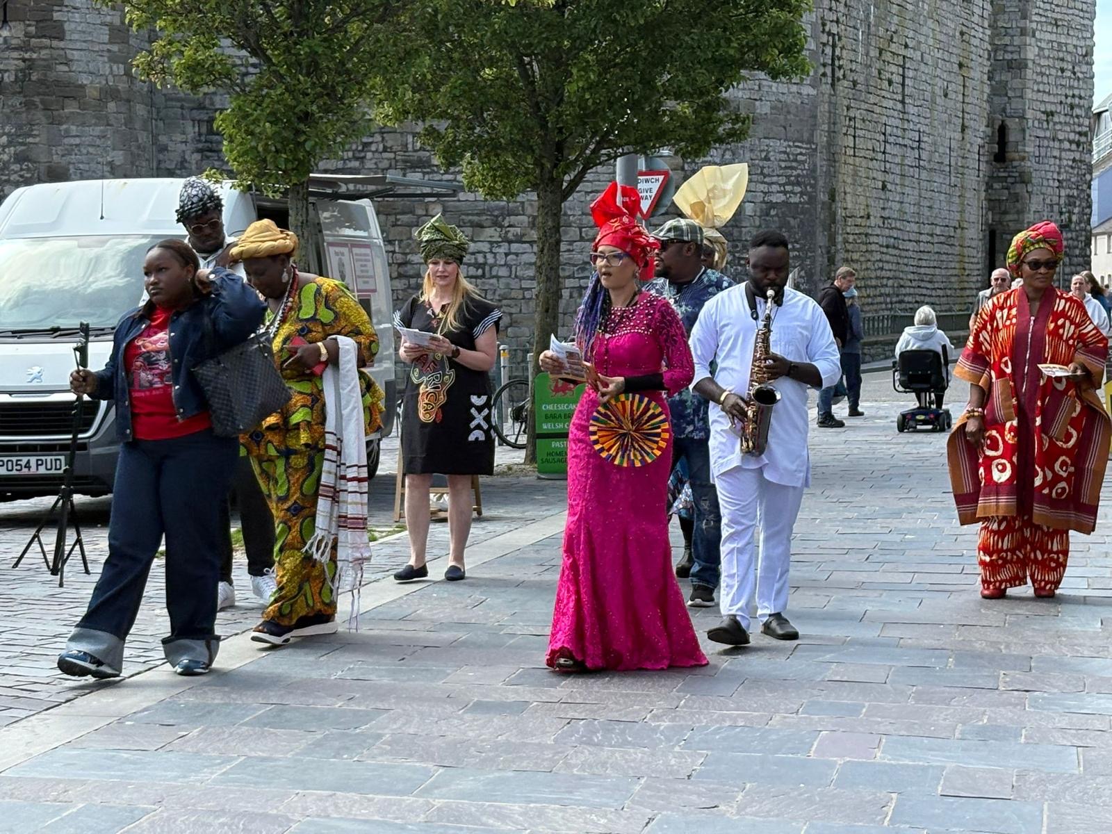 Musicians and participants gathered outside a stone arch